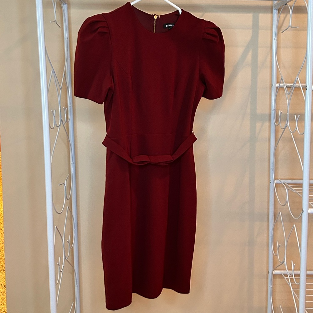 Burgundy Express office dress with detailed puff sleeve and thin belt accent.